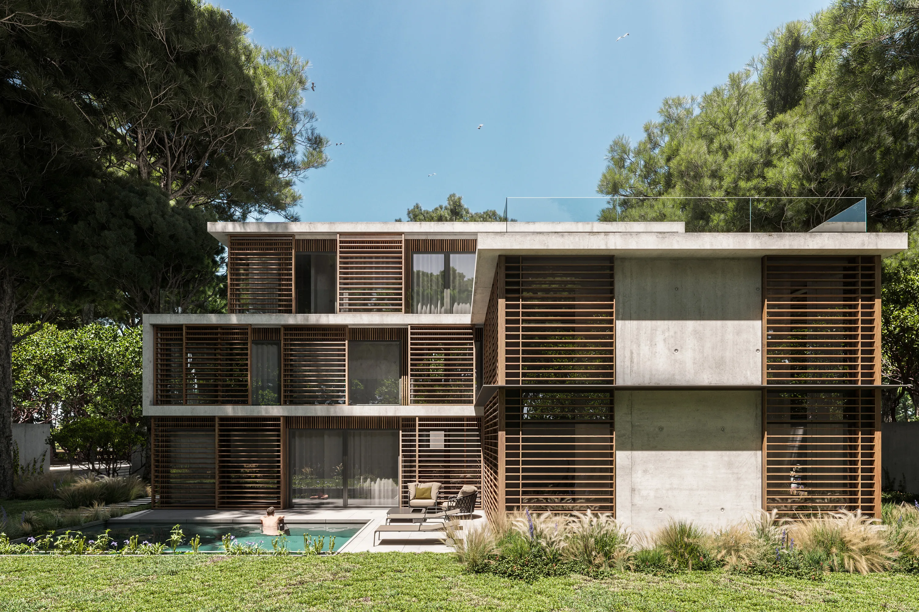 Vista frontal de la villa de hormigón y madera entre las dunas de Castelldefels